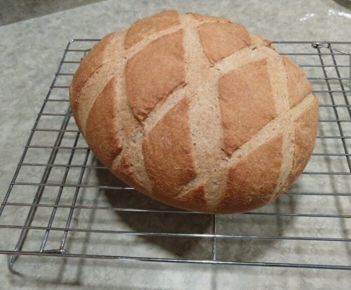 A pleasantly nutty brown colored bread scored in a criss cross pattern