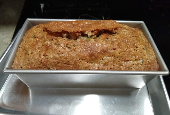 A loaf of zucchini bread that has a satisfying crack across the top