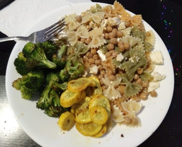 a plate of noodles mixed with chickpeas and feta, plus some roasted broccoli and yellow squash