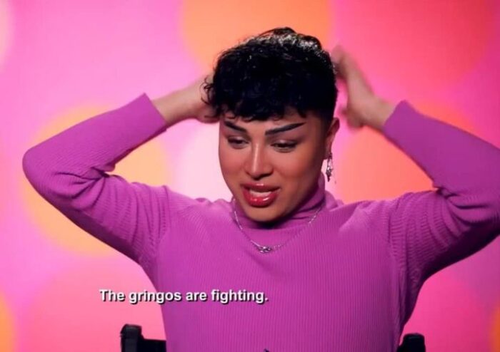 Screenshot of Morphine Love Dion, a Latina, from season 16 of RuPaul's Drag Race. The subtitle reads "The gringos are fighting"