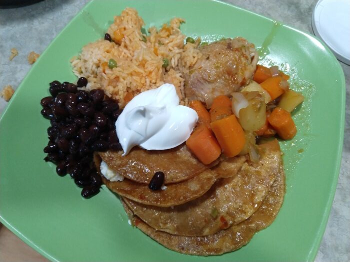 A plate of enchiladas mineras, beans and rice