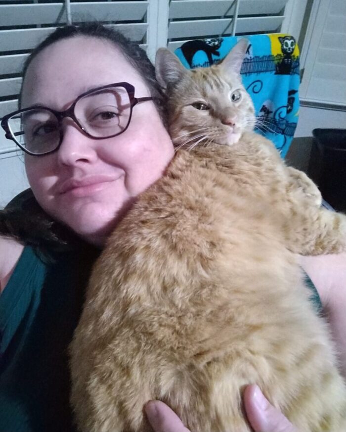 Me cuddling with Fritz. I'm holding him against my chest and shoulder. His face is pressed against mine and we are both looking towards the camera