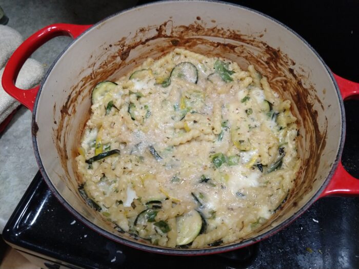 large pot of based baked with squash and melty cheese, with herbs flecked throughout