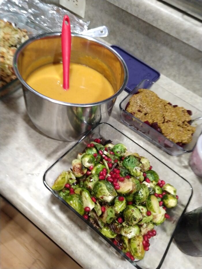 A pot of butternut squash soup; beets with pistachio butter, brussels sprouts with balsamic-pomegranate glaze