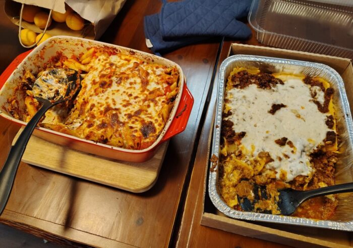 A pan of lentil pasta topped with browned, melty cheese and another pan of lasagna