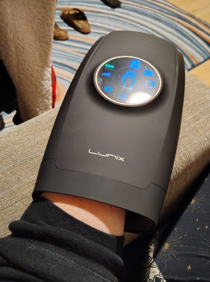 My hand hidden in an Iron Man-looking device that massages my hand and wrist