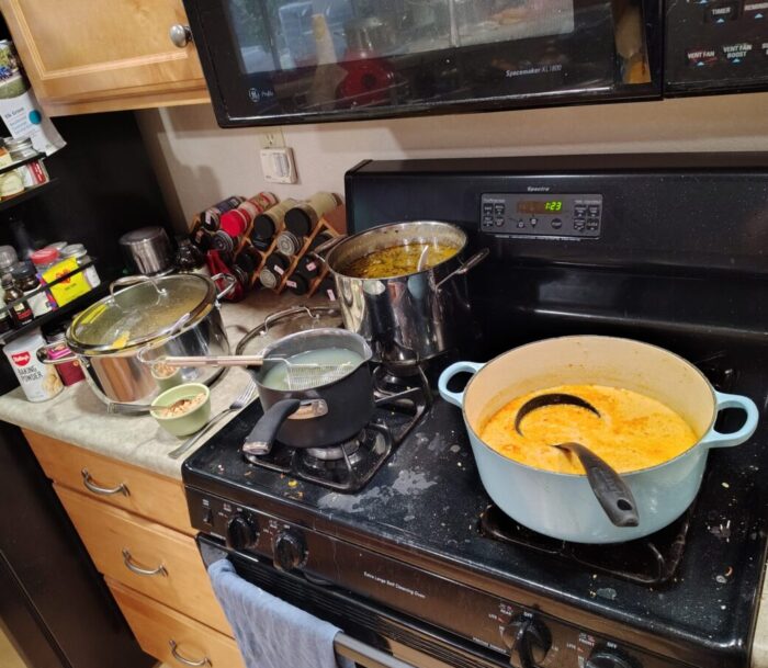 Several pots of soup on my stove and countertop