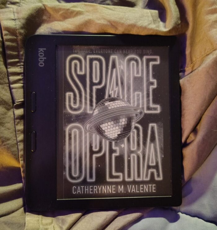book cover for Space Opera featuring a disco ball with rings like a planet. Greyscale on kobo ereader