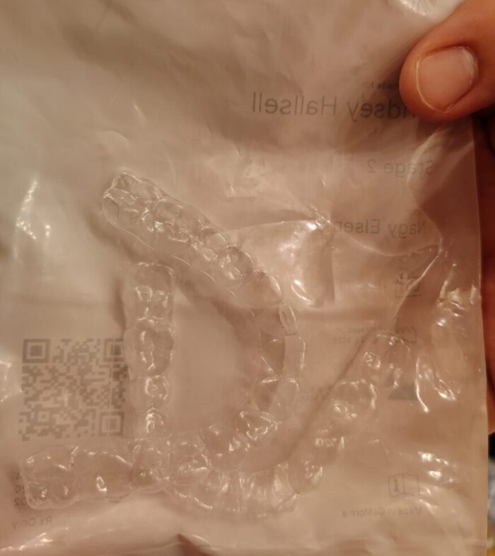 a small plastic bag with a set of clear braces inside