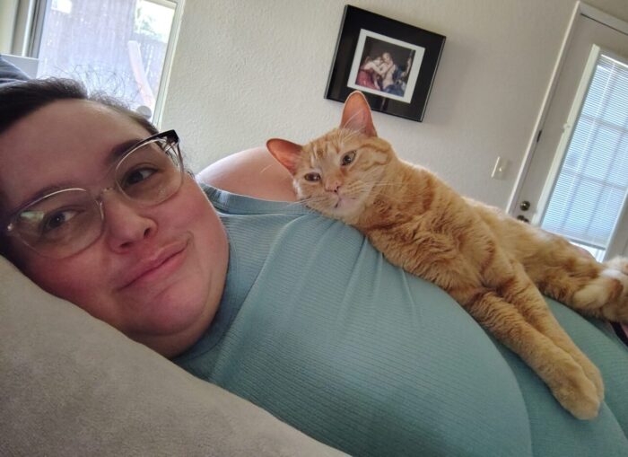 Fritz the cat lying on top of me. I'm on my side, looking at the camera. Fritz has is legs stretched out in front of him