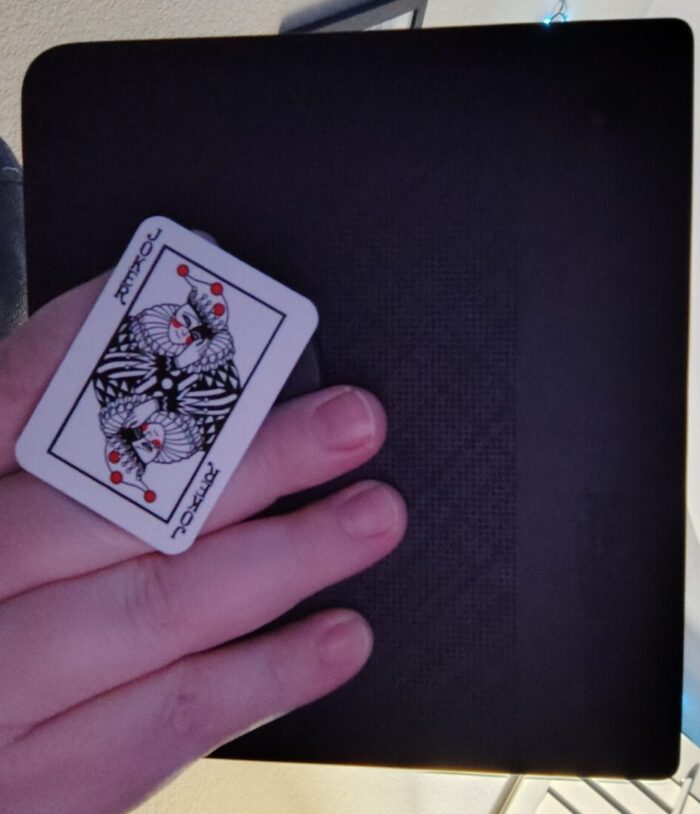 a popsocket designed like a playing card with a harlequin joker on it