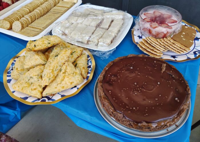 Chocolate-caramel tart, scones, and other garden party snacks arrayed on a table