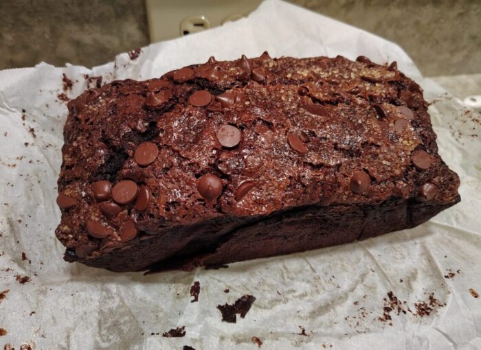 a freshly baked loaf of chocolate zucchini bread, topped with chocolate chips and turbinado sugar