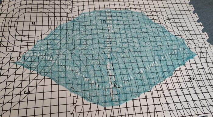 25 grams of love shawl stretched out and pinned on a foam board