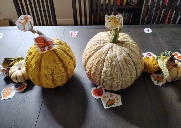 decorate gourds as a centerpiece on the dining table with little cut-out pictures of emoji mashups like a unicorn with a corn mane and a roller skate with jack-o-lantern wheels
