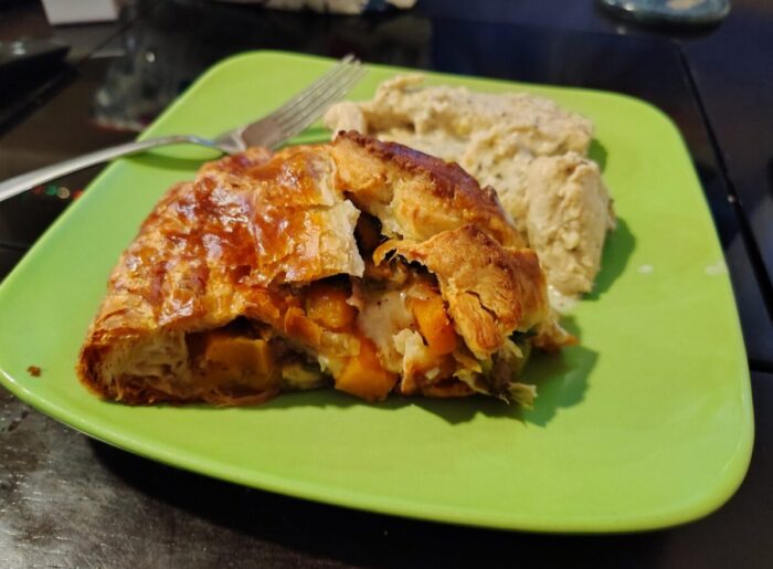 a plate with a piece of baked brie and caramelized vegetable pie and some creamy garlic chicken