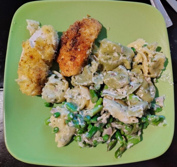 a plate of tortellini primavera and some pan-fried chicken tenders