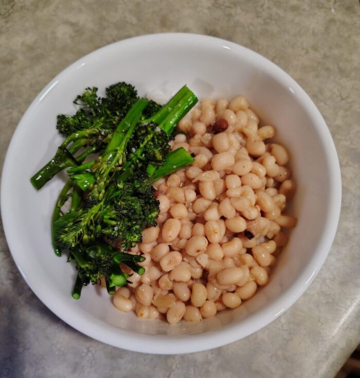 a bowl of beans and broccolini over rice