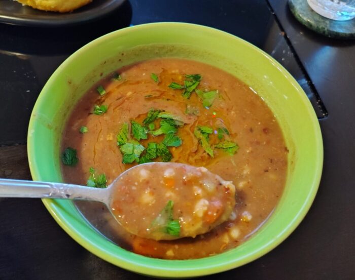 a bowl of bean and barley soup topped with a drizzle of olive oil and a bit of parsley