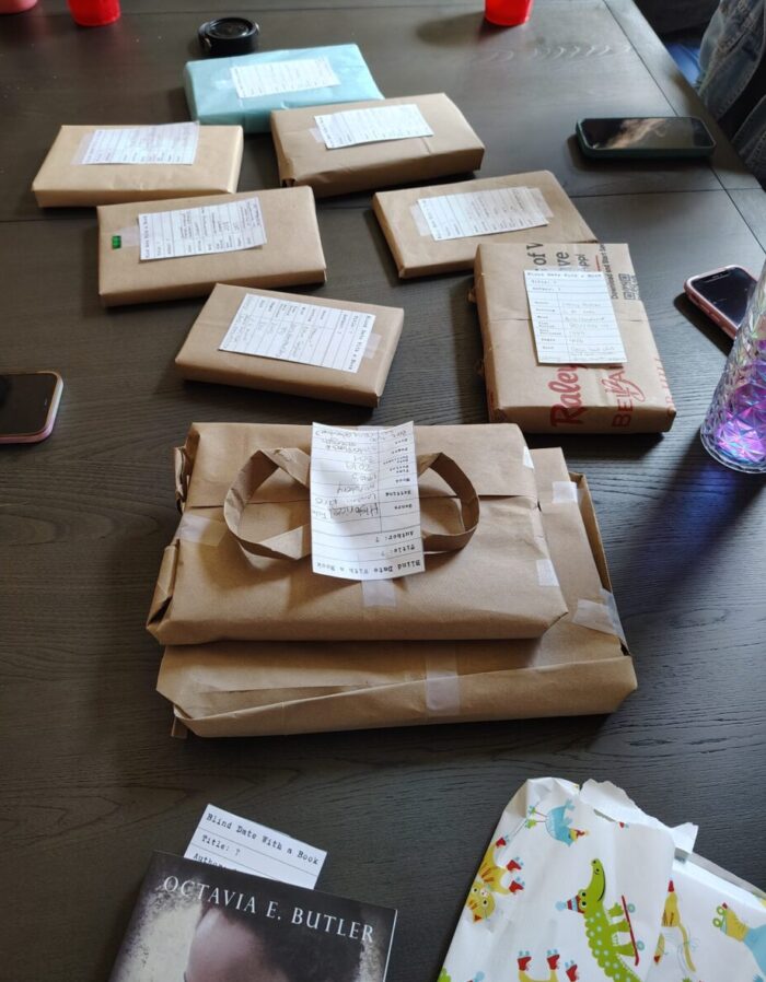 brown-paper wrapped books scattered on the dining table. Each has a "blind date with a book" tag that provides some details