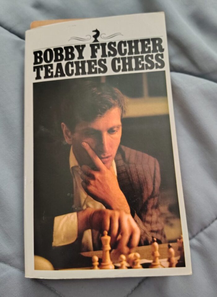 paperback book of Bobby Fischer Teaches Chess. The cover features Bobby Fischer apparently thinking deeply about his next chess move