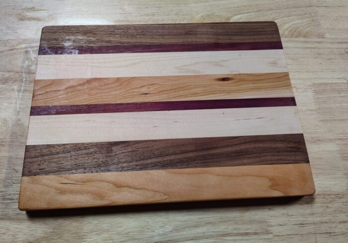 a cutting board made with eight slats of four colors of wood