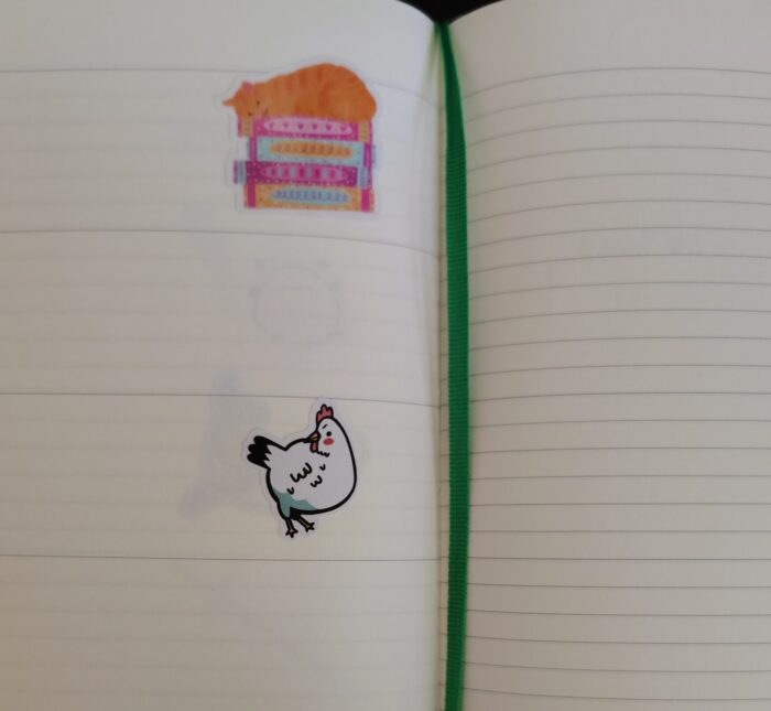 my planner with stickers of a sassy chicken and an orange cat snoozing on a pile of books