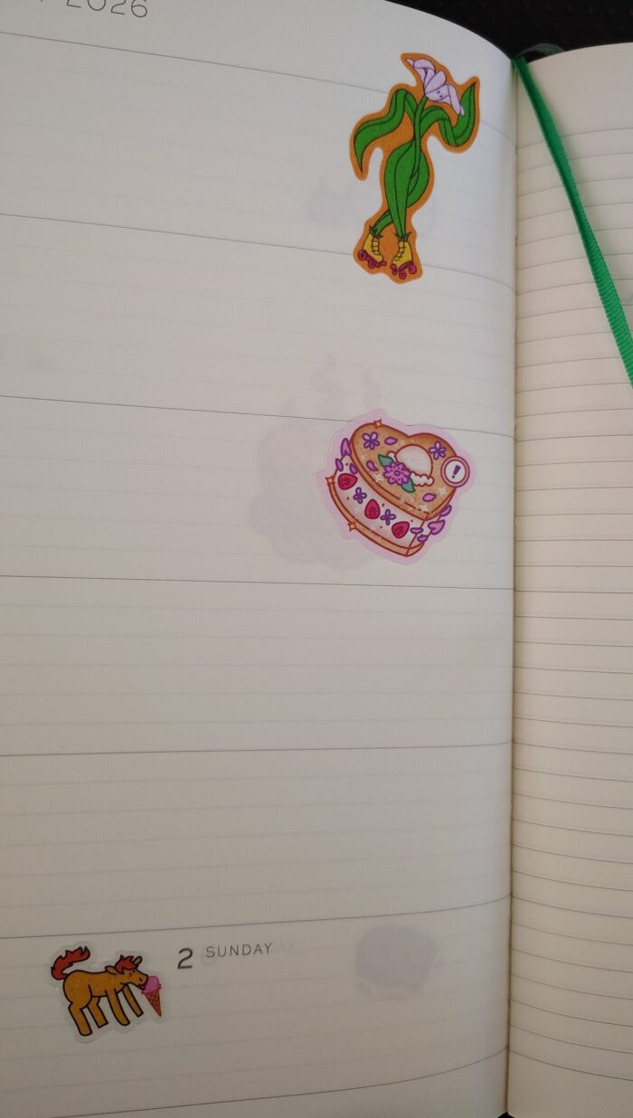 stickers in my planner featuring a flower on roller skates, an ice cream sandwich, and a unicorn with an ice cream cone