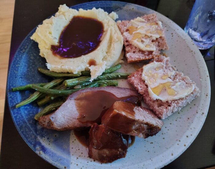 a plate of tri tip, green beans, mashed potatoes, and cornbread