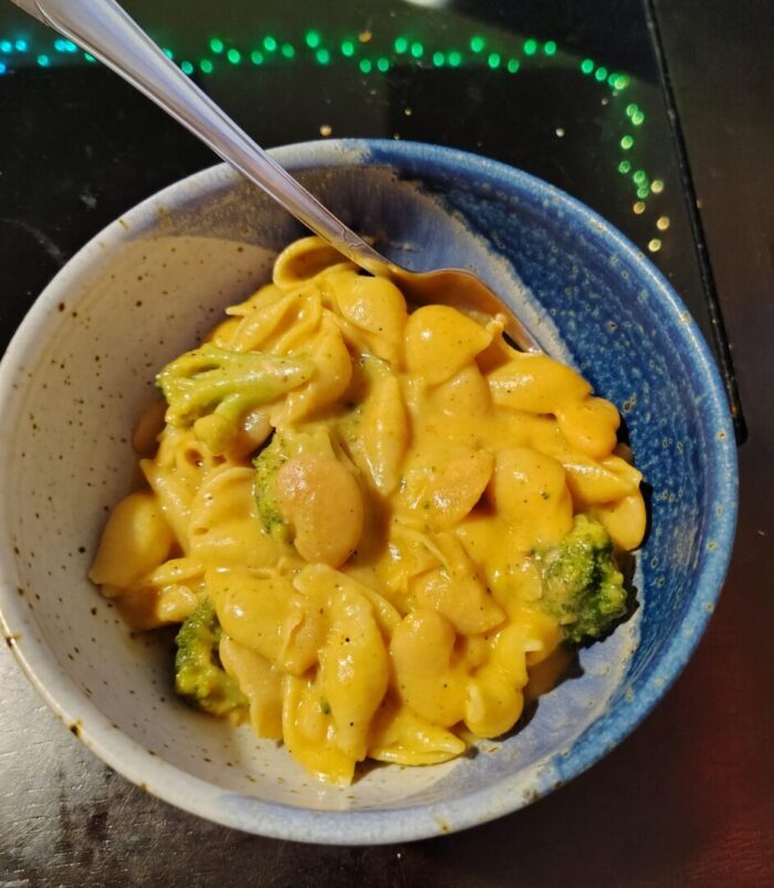 a bowl of beans, broccoli, and shell noodles in cheese sauce