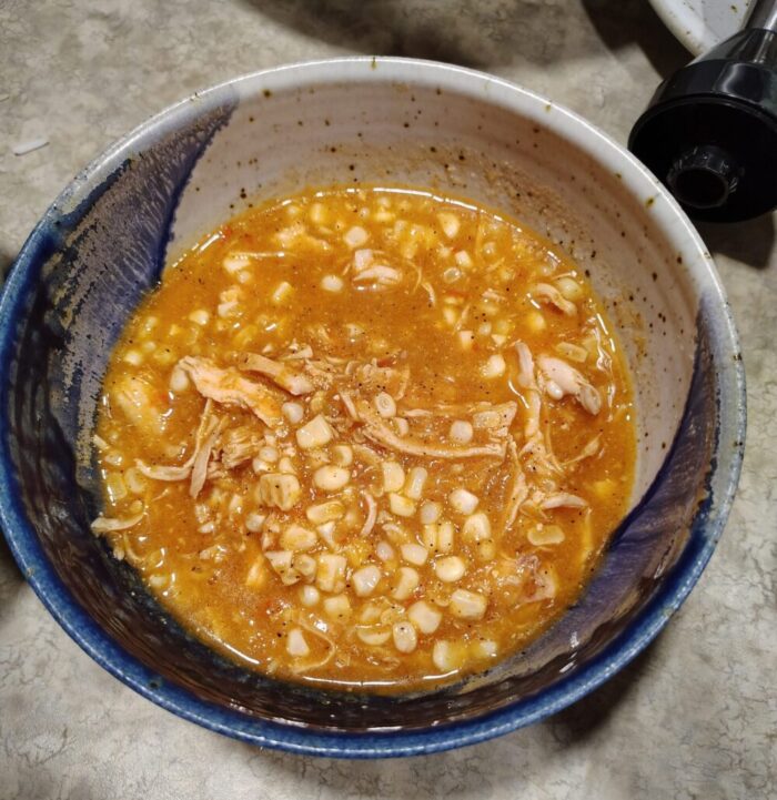 a bow of soup fully of spicy chicken and corn