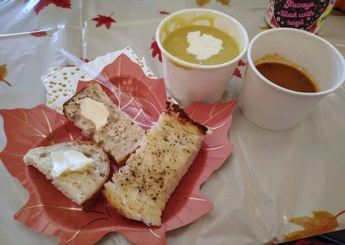 two small cups of soup and a plate of breads for dipping