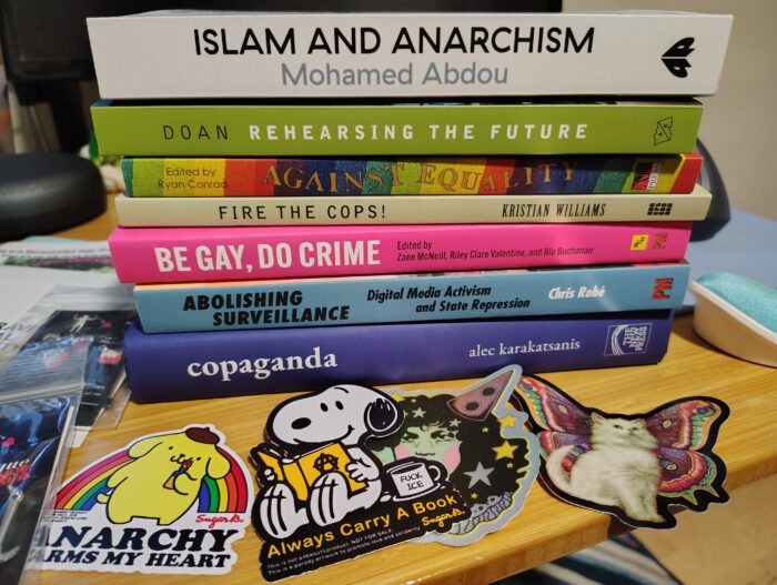 stack of books including Islam and Anarchism, Rehearsing the Future, Copaganda, and Abolishing Surveillance
